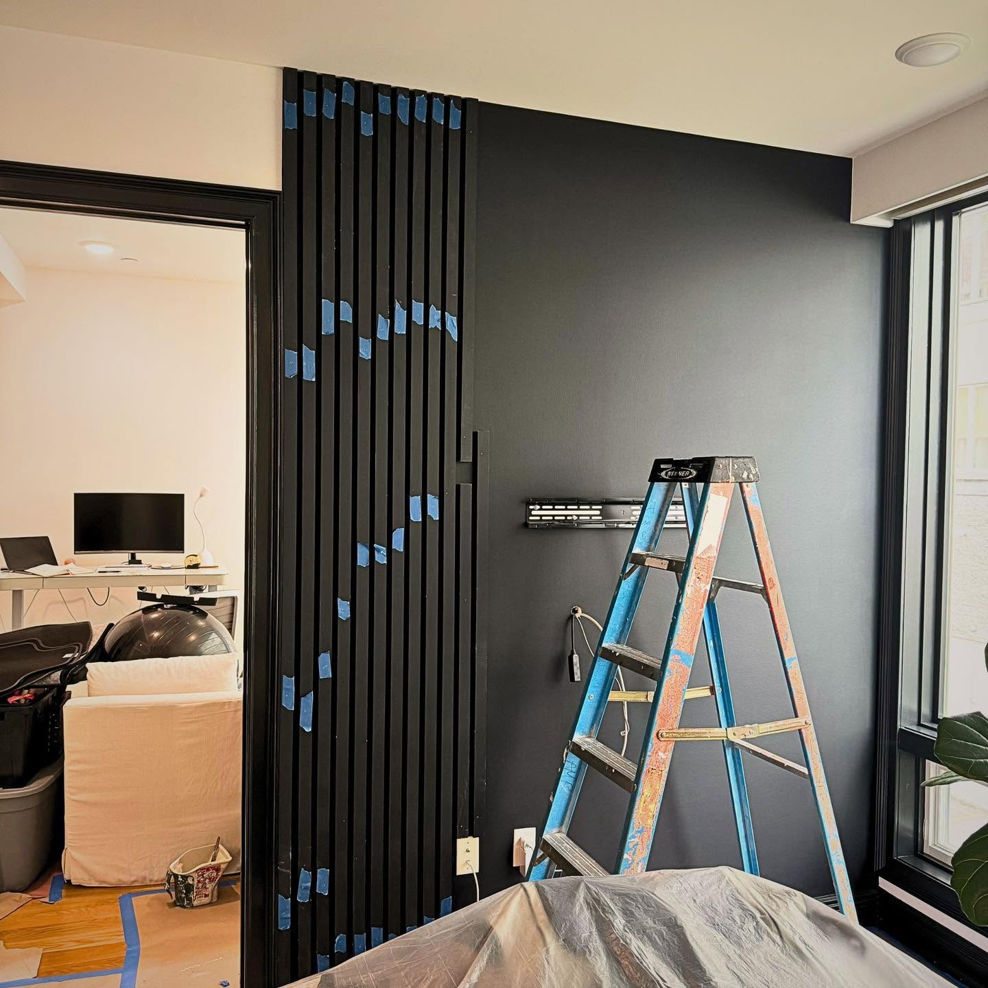 Black slat accent wall — install underway